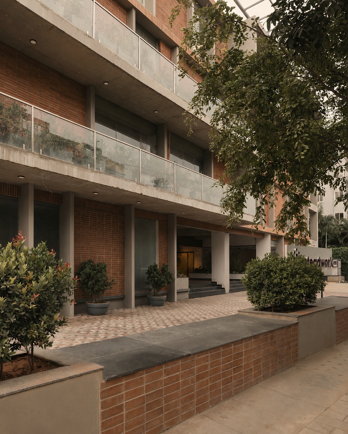 Steadwork ORR | Panathur building exterior, brick and concrete facade with planted terraces and mature trees
